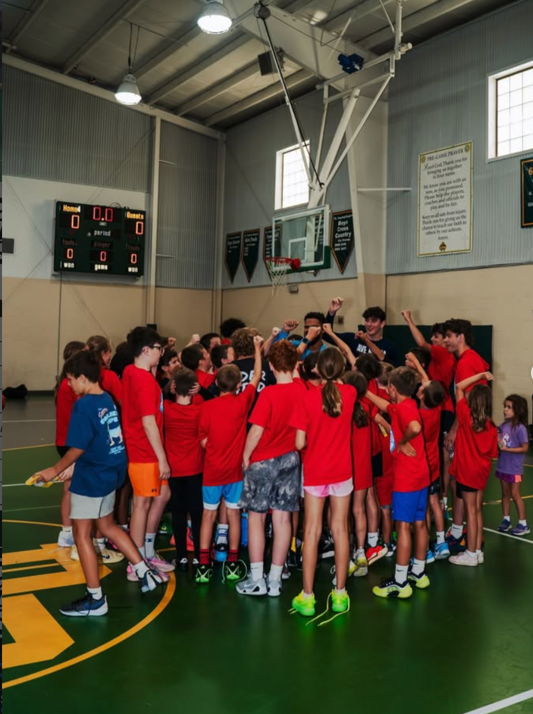 LCTB players bring their hands together in a team huddle on the basketball court